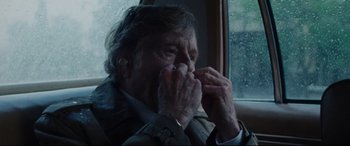 Movie still from “The Old Man & the Gun” (2018), directed by David Lowery – An older man sitting in a car eating something; Close Up shot, Over the shoulder angle