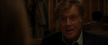 Movie still from “The Old Man & the Gun” (2018), directed by David Lowery – An older man is smiling for the camera; Close Up shot, Over the shoulder angle