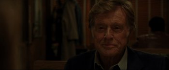 Movie still from “The Old Man & the Gun” (2018), directed by David Lowery – An older man in a black suit and white shirt; Close Up shot, Over the shoulder angle