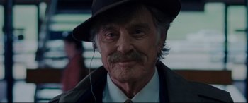 Movie still from “The Old Man & the Gun” (2018), directed by David Lowery – An older man wearing a hat and headphones; Close Up shot, Low angle