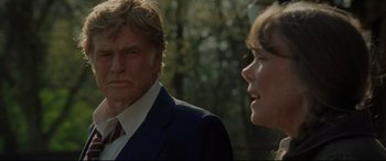 Movie still from “The Old Man & the Gun” (2018), directed by David Lowery – A man and a woman standing next to each other in front of trees; Close Up shot, Over the shoulder angle
