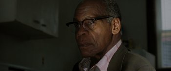 Movie still from “The Old Man & the Gun” (2018), directed by David Lowery – An older man wearing glasses and a jacket; Close Up shot, Over the shoulder angle