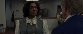 Movie still from “The Old Man & the Gun” (2018), directed by David Lowery – A woman in a gray vest and a white bow tie; Close Up shot, Over the shoulder angle