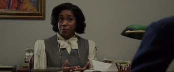 Movie still from “The Old Man & the Gun” (2018), directed by David Lowery – A woman sitting at a desk in front of papers; Close Up shot, Over the shoulder angle