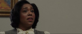 Movie still from “The Old Man & the Gun” (2018), directed by David Lowery – A woman in a white shirt and a gray vest looking upward; Close Up shot, Over the shoulder angle