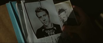 Movie still from “The Old Man & the Gun” (2018), directed by David Lowery – An old photo of a man with a police badge hanging on a pin; Close Up shot, Over the shoulder angle