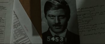 Movie still from “The Old Man & the Gun” (2018), directed by David Lowery – A black and white photo of a man in a suit and tie; Close Up shot, Over the shoulder angle