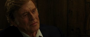 Movie still from “The Old Man & the Gun” (2018), directed by David Lowery – An older man in a suit and tie looking at the camera; Close Up shot, Over the shoulder angle