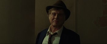 Movie still from “The Old Man & the Gun” (2018), directed by David Lowery – An older man wearing a hat and a tie; Close Up shot, Over the shoulder angle