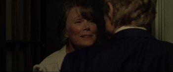 Movie still from “The Old Man & the Gun” (2018), directed by David Lowery – An older woman smiling at a younger man in a suit; Close Up shot, Over the shoulder angle