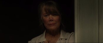 Movie still from “The Old Man & the Gun” (2018), directed by David Lowery – An older woman with long hair is posing for the camera; Close Up shot, Low angle