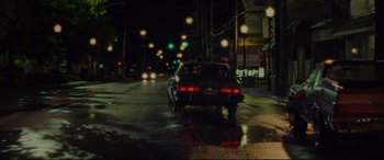 Movie still from “The Old Man & the Gun” (2018), directed by David Lowery – A car is driving down the street at night; Extreme Wide shot, Over the shoulder angle