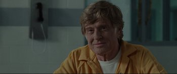 Movie still from “The Old Man & the Gun” (2018), directed by David Lowery – An older man wearing an orange jacket and white shirt; Close Up shot, Over the shoulder angle