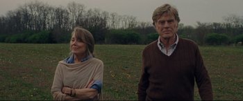 Movie still from “The Old Man & the Gun” (2018), directed by David Lowery – A man and a woman standing next to each other in a field; Medium shot, Low angle