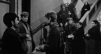 Movie still from “The Organizer” (1963), directed by Mario Monicelli – A group of men standing next to each other on stairs; Medium shot, Over the shoulder angle