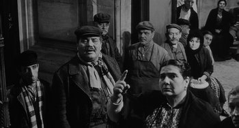Movie still from “The Organizer” (1963), directed by Mario Monicelli – A group of men and women standing next to each other; Medium shot, Over the shoulder angle