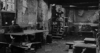 Movie still from “The Organizer” (1963), directed by Mario Monicelli – Two people standing in an old building with a table and chairs; Wide shot, High angle