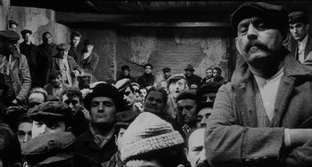 Movie still from “The Organizer” (1963), directed by Mario Monicelli – A group of people sitting in front of an audience; Medium shot, Low angle