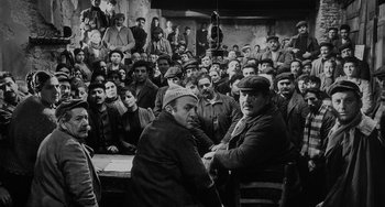 Movie still from “The Organizer” (1963), directed by Mario Monicelli – A group of men sitting in front of each other; Wide shot, High angle