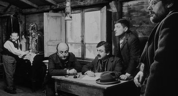 Movie still from “The Organizer” (1963), directed by Mario Monicelli – A group of men sitting around a table; Medium shot, Over the shoulder angle