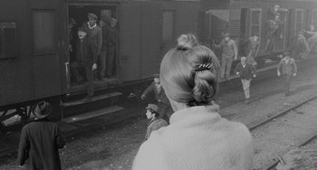 Movie still from “The Organizer” (1963), directed by Mario Monicelli – A woman is standing in front of a group of men; Medium shot, Over the shoulder angle