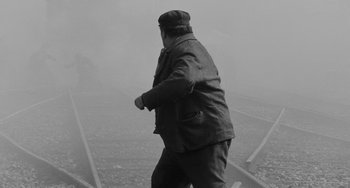 Movie still from “The Organizer” (1963), directed by Mario Monicelli – A man walking down a train track on a foggy day; Wide shot, High angle