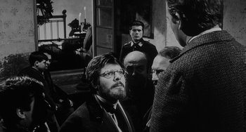 Movie still from “The Organizer” (1963), directed by Mario Monicelli – Black and white photograph of a group of men in a room; Medium shot, Over the shoulder angle