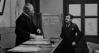 Movie still from “The Organizer” (1963), directed by Mario Monicelli – Two men standing in front of a chalkboard; Medium shot, Over the shoulder angle