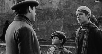 Movie still from “The Organizer” (1963), directed by Mario Monicelli – A group of people standing next to each other; Medium shot, Over the shoulder angle