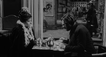 Movie still from “The Organizer” (1963), directed by Mario Monicelli – A man and a woman sitting at a table; Medium shot, Over the shoulder angle