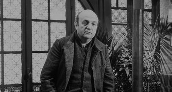 Movie still from “The Organizer” (1963), directed by Mario Monicelli – An older man wearing a jacket standing in front of a window; Medium shot, Low angle