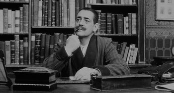 A black and white photo of a man sitting at a desk