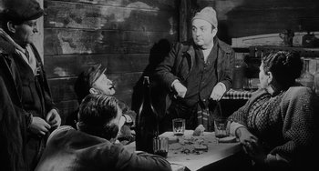 Movie still from “The Organizer” (1963), directed by Mario Monicelli – A group of people sitting around a table; Medium shot, Over the shoulder angle