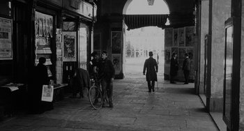 Movie still from “The Organizer” (1963), directed by Mario Monicelli – A man walking down a street with a bicycle; Wide shot, High angle