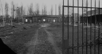 Movie still from “The Organizer” (1963), directed by Mario Monicelli – An empty field with a metal gate in the middle of it; Extreme Wide shot, High angle