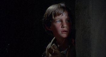 Movie still from “The Other” (1972), directed by Robert Mulligan – A young boy is standing next to a wall; Close Up shot, Low angle