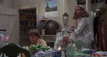Movie still from “The Other” (1972), directed by Robert Mulligan – Two people sitting at a dining table in a kitchen; Medium shot, Over the shoulder angle