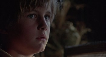 Movie still from “The Other” (1972), directed by Robert Mulligan – A child's face in a dark room; Close Up shot, Low angle