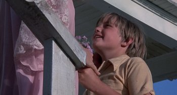 Movie still from “The Other” (1972), directed by Robert Mulligan – A young boy holding a large knife up to a wall; Close Up shot, Low angle