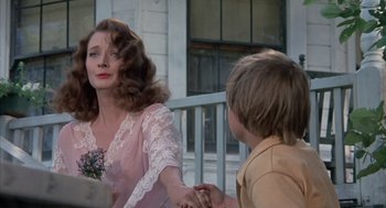 Movie still from “The Other” (1972), directed by Robert Mulligan – A woman and a boy are holding hands outside; Close Up shot, Over the shoulder angle
