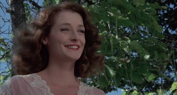 Movie still from “The Other” (1972), directed by Robert Mulligan – A woman with long red curly hair smiling for the camera; Close Up shot, Low angle