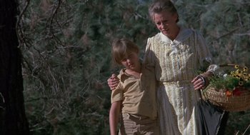 Movie still from “The Other” (1972), directed by Robert Mulligan – An older woman and a young boy walking in a forest; Medium shot, Low angle