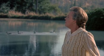 Movie still from “The Other” (1972), directed by Robert Mulligan – An older woman standing in front of a body of water; Medium shot, Over the shoulder angle