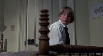 Movie still from “The Other” (1972), directed by Robert Mulligan – A boy in a white dress shirt and black neck tie; Close Up shot, Low angle