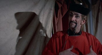 Movie still from “The Other” (1972), directed by Robert Mulligan – A man in a red robe and a black hat; Close Up shot, Over the shoulder angle