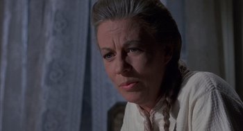 Movie still from “The Other” (1972), directed by Robert Mulligan – An older woman wearing a white shirt and a pink neck tie; Close Up shot, Low angle