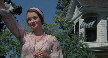 Movie still from “The Other” (1972), directed by Robert Mulligan – A woman in a floral dress waving at the camera; Medium shot, Low angle