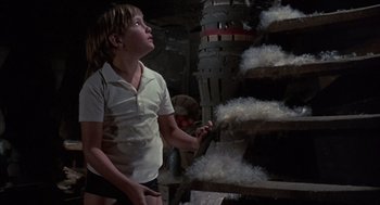Movie still from “The Other” (1972), directed by Robert Mulligan – A young girl is looking up at a pile of wool; Medium shot, Low angle