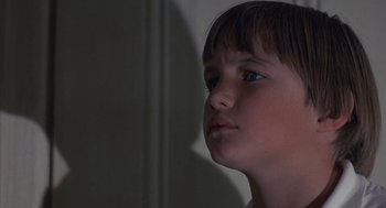 Movie still from “The Other” (1972), directed by Robert Mulligan – A young boy with blue eyes stares into the distance; Close Up shot, Low angle