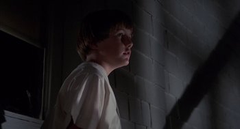 Movie still from “The Other” (1972), directed by Robert Mulligan – A young boy standing next to a brick wall; Medium shot, Low angle